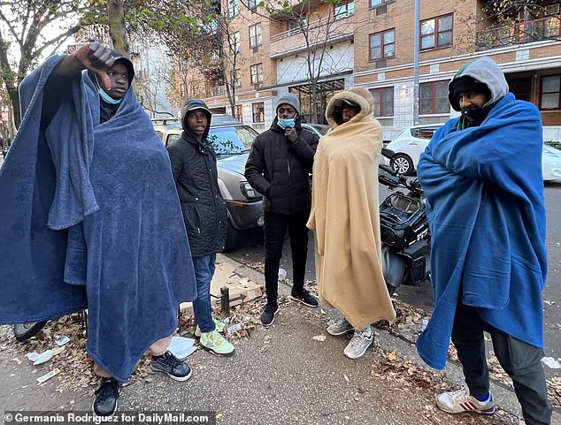 Ibrahim, from Chad (far left) has been waiting for new temporary housing for five days, claiming officials keep telling him to come back the next day