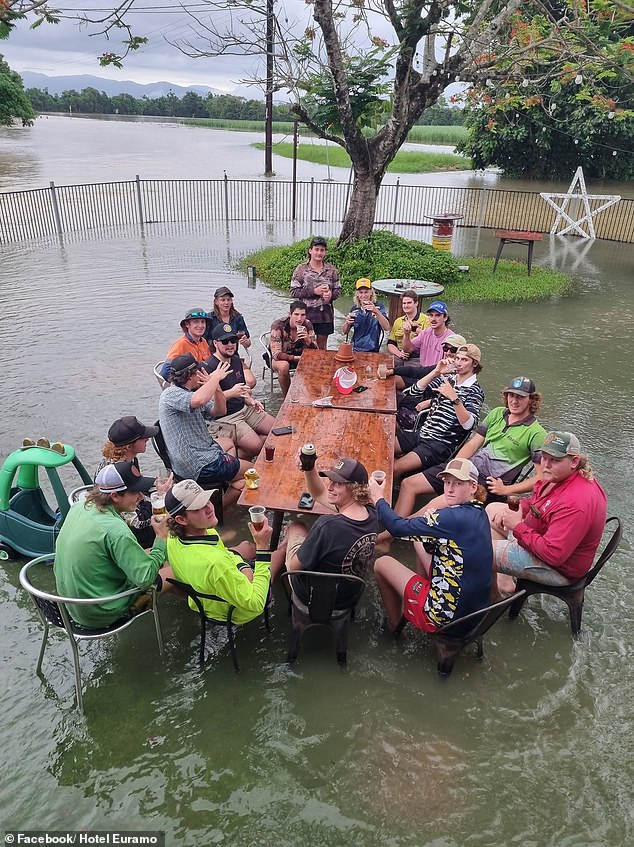 Undeterred by the beer garden which is increasingly becoming a paddling pool, visitors to the Euramo pub enjoy a refreshing drink outside