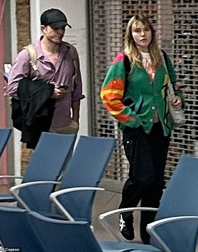 Actress Suki, 31, covered up her blossoming baby bump as she wore a multi-colored cardigan and donned baggy cargo pants for her eight-hour return journey