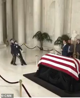 A military member collapses at the end of O'Connor's casket at the Supreme Court on Monday