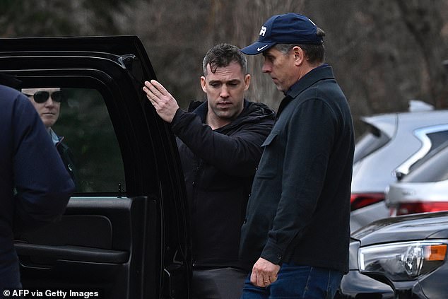 Hunter Biden is led back into a waiting black SUV by Secret Service agents after he and President Joe Biden visited a jewelry store in Wilmington on Monday