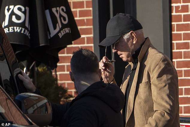 President Joe Biden puts on his signature aviator sunglasses as he walks to the waiting motorcade after the departing luncheon in Wilmington on Monday