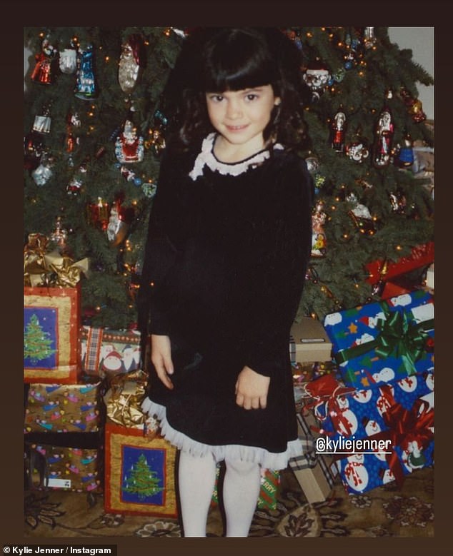 Jenner added a throwback photo of herself as a little girl standing in front of a Christmas tree filled with a variety of similar decorations