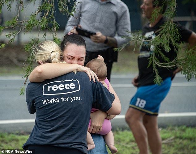 Evacuees reunite with family members at the Barron River bridge in north Cairns