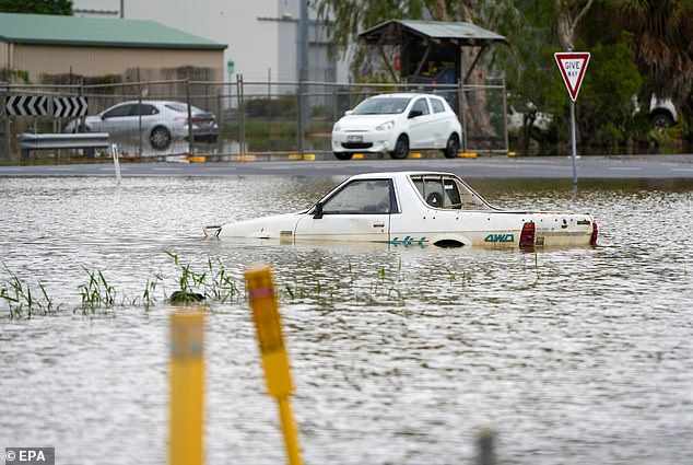 A submerged car is seen in the water in the Cairns suburb of Aeroglen