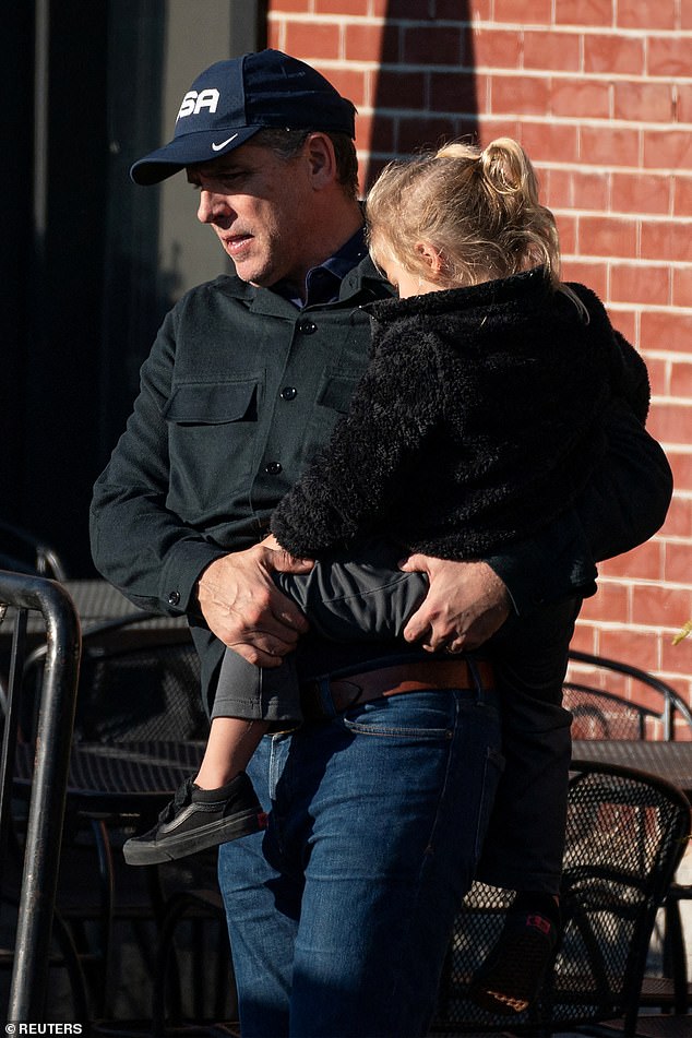 Pictured: L Hunter Biden holding son Beau Biden Jr.  stuck while leaving a restaurant in Wilmington, Delaware, on Monday