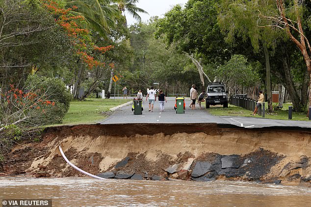 Residents are being cut off after a large section of road was washed away at Holloways Beach, Cairns