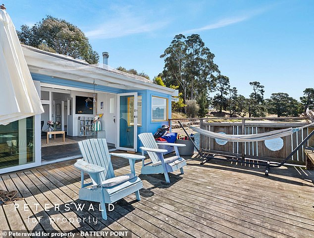 Glass doors highlight the sparkling bay views and lead to the wooden sundeck and expansive private jetty