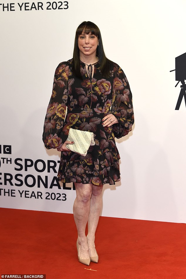 The retired artistic gymnast, 38, wore a black and brown floral print dress that ended just above her knee