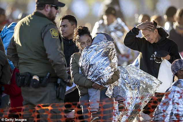 About 2,000 migrants cross the southern border every day, with Texas bearing the brunt of the crisis over the past five years.  Pictured: A U.S. Border Patrol agent watches immigrants enter a transit center after illegally crossing Eagle Pass, Texas from Mexico