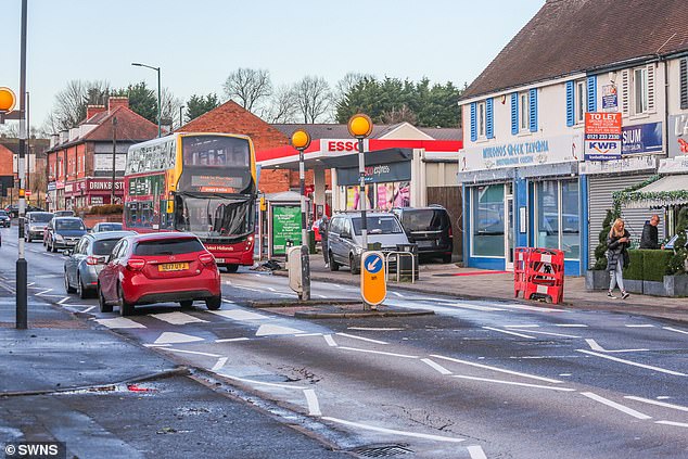 General view of Warwick Road in Olton, Solihull, taken today, shows the car driving onto the wrong side of the road and crashing into the now-removed lamppost (right)