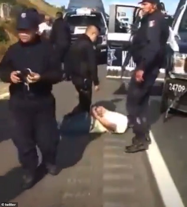 A police officer stands over one of the two occupants who were riding in the vehicle driven by actor Octavio Ocaña before he accidentally shot himself in the head and crashed shortly after one of the officers rammed the department's SUV into Ocaña's vehicle.