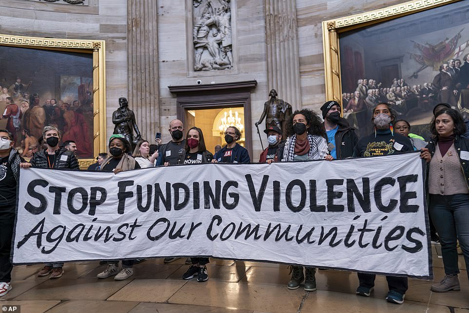 “Stop funding violence against our communities,” read a large sign that protesters held aloft in the Capitol Rotunda.  “Divesting militarism – investing in life,” read other signs that protesters waved above their heads.  'Protect immigrants and asylum seekers' and 'ceasefire' read others.