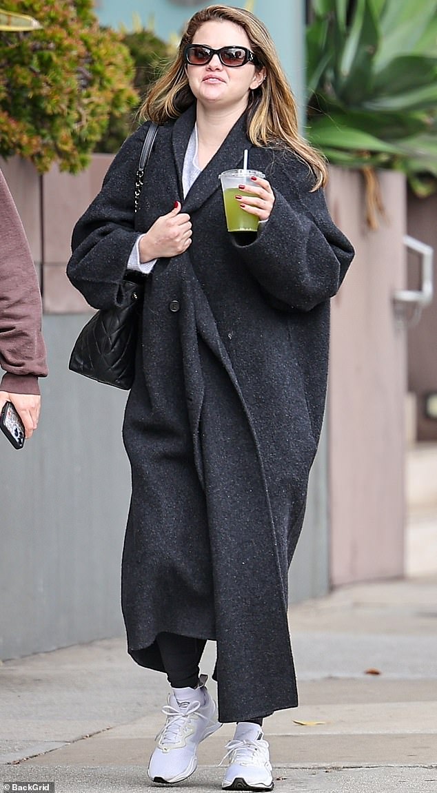 The 31-year-old actress, dressed in a cozy gray trench coat, stepped out to grab sushi and go shopping in Beverly Hills with her friend Anna Collins