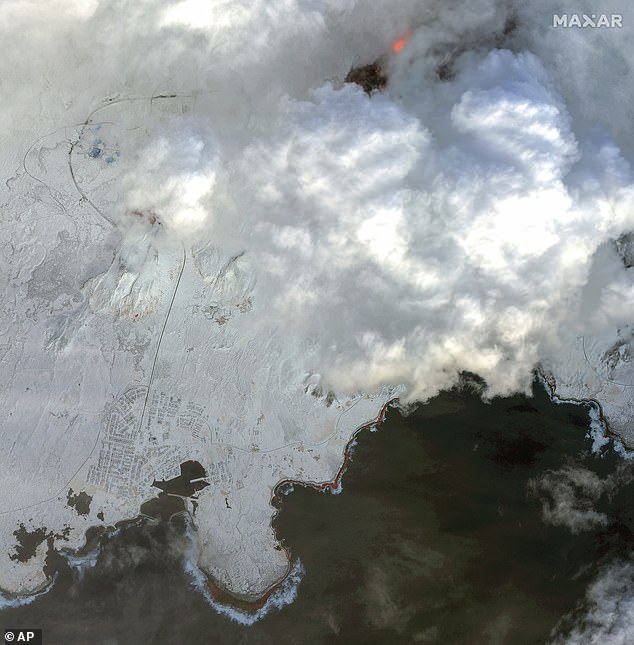 This satellite image from Maxar Technologies shows a color infrared view of Grindavik and lava from a volcano in Iceland