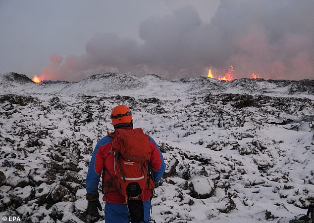 A rescue worker walks in an area near a volcanic eruption in Iceland on Monday