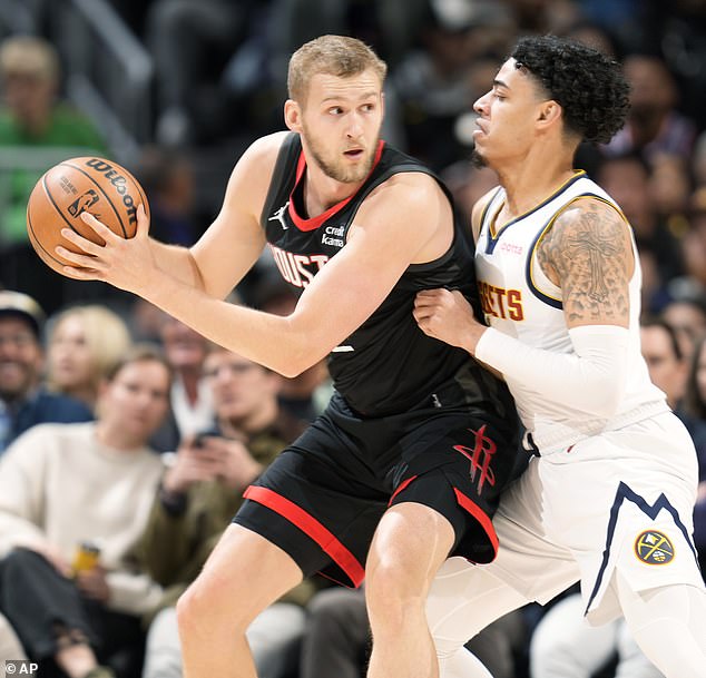 Houston Rockets star Jock Landale (left) appears to drive to the rim as Denver Nuggets guard Julian Strawther defends in the first half of an NBA basketball game on Nov. 29.  Landale is accused of being a school bully