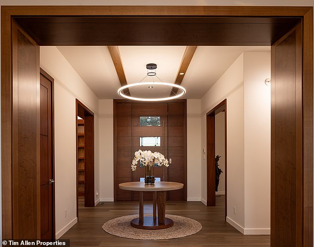 The entrance way is illuminated by a large round, abstract lamp, with visible dark wooden beams on the top and side.  MacNeil also redid the roof with copper and created a custom front door