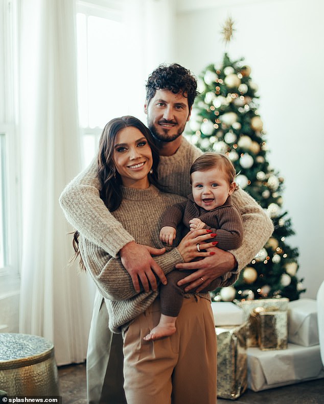 Johnson, 29, and Chmerkovskiy, 37, who welcomed their firstborn in January, cradled their son as they posed in front of a glittering tree ahead of Rome's first Christmas.