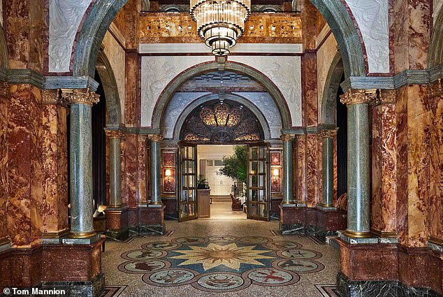 The brown and cream marbled entrance hall is “dark and luxurious,” says Carlton