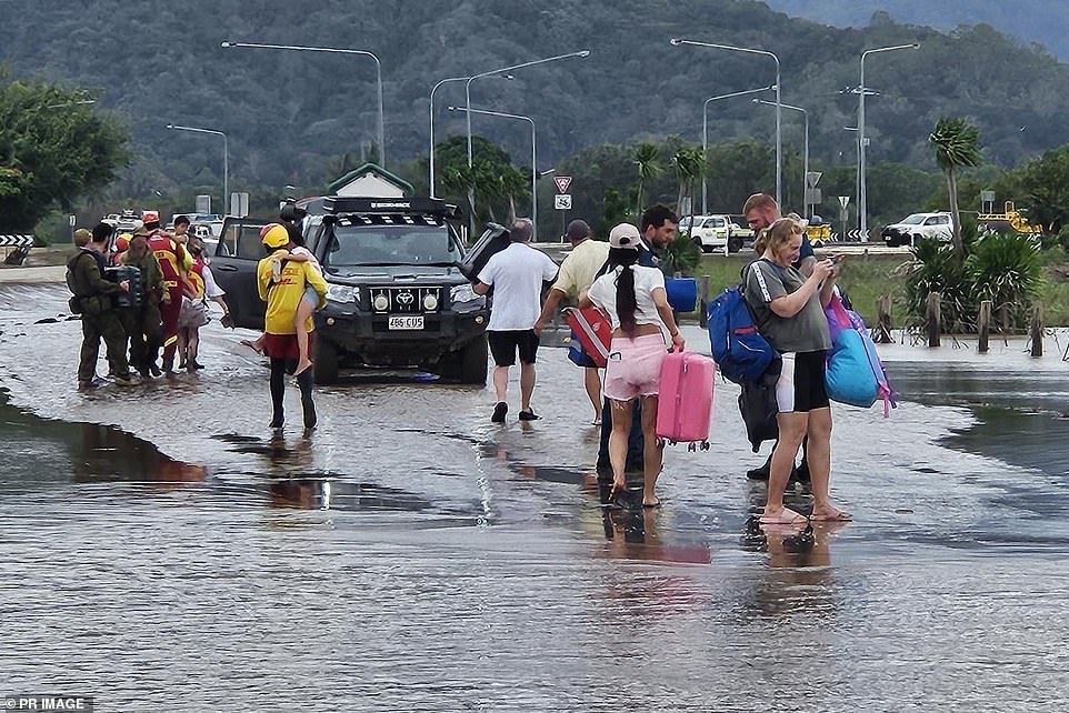 Rescue efforts are still underway in parts of North Queensland after severe flooding (Photo: Police and Defense help residents evacuate on Monday)