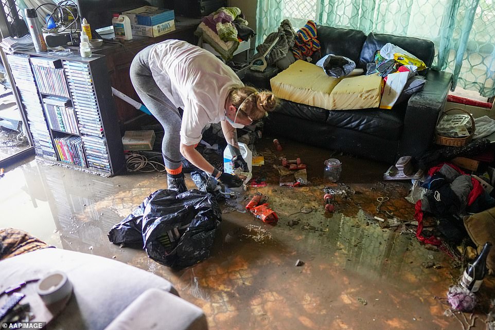 Regional Council Mayor Terry James said 1,400 homes damaged in Cairns (pictured woman cleaning her Cairns home on Tuesday)