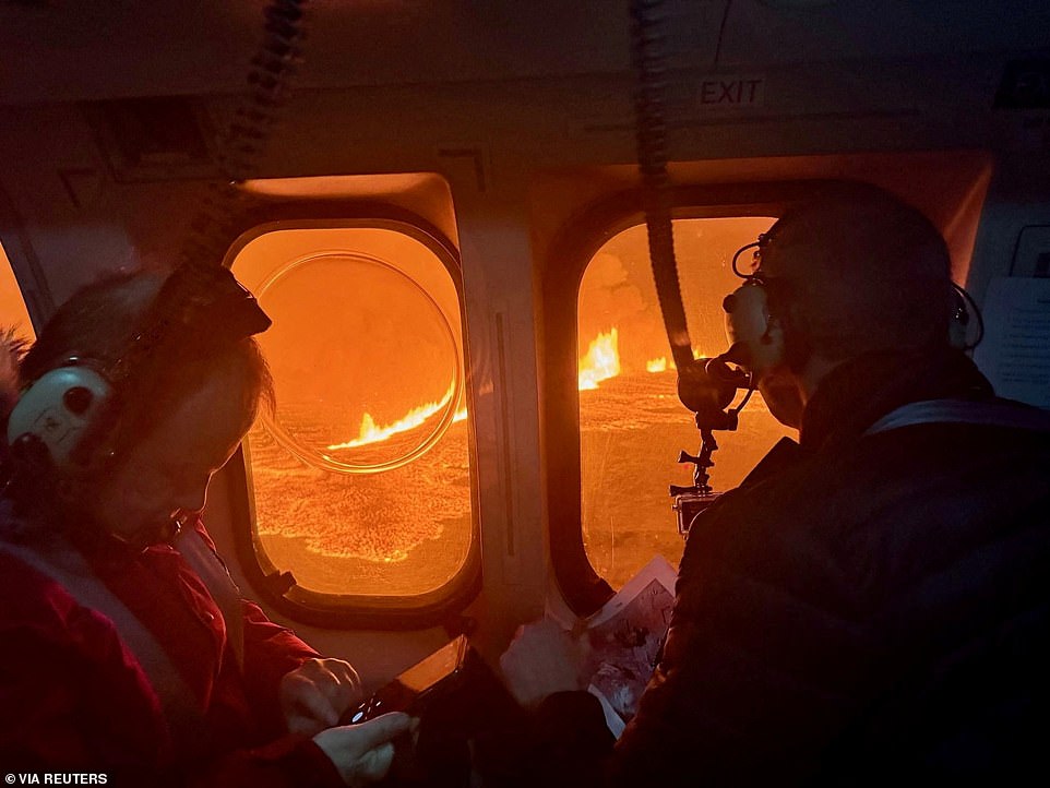 The plane was called to the eruption site on the Reykjanes Peninsula to search for the hiker, who flagged down the passing helicopter using SOS signals, the Icelandic Coast Guard said.  Pictured: A helicopter flies near a volcano spewing lava and smoke as it erupts near Grindavik, December 19