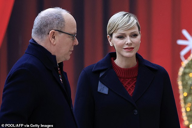 Albert paired his red accessory – decorated with designs of Santa Claus, Christmas trees, stockings and presents – with a crisp white shirt and a navy blue jacket and trousers