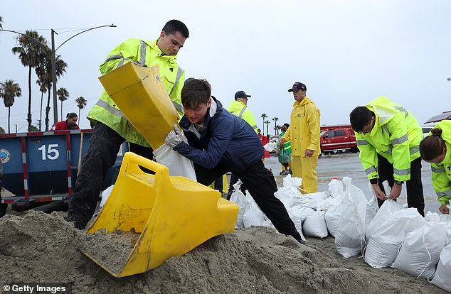 Volunteers and members of the Long Beach Fire Department fill sandbags on Belmont Shore Beach before Hilary on August 20, 2023