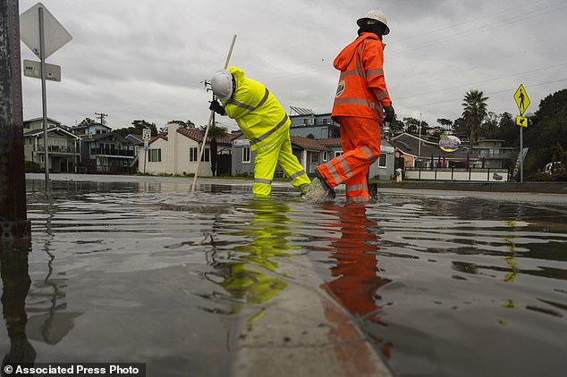 Santa Cruz County Public Works crews clear a storm drain in the Rio Del Mar neighborhood of Aptos, California on Wednesday, December 20, 2023