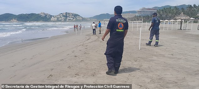 Officials are seen on beaches along Mexico's Pacific coast in the aftermath of the horrific attack