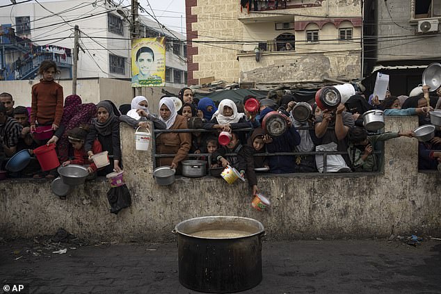 Palestinians queue for a free meal in Rafah, Gaza Strip, Thursday, December 21