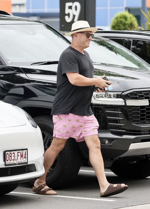 The television star did his shopping in a black T-shirt and summer shorts with a pink pattern