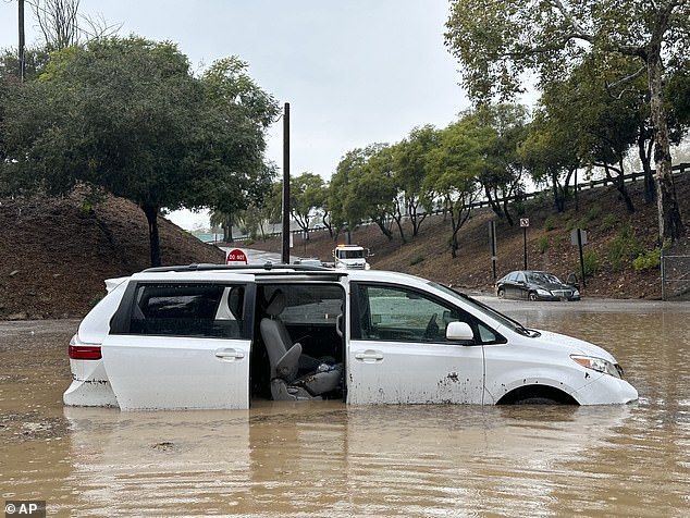 A vehicle becomes flooded at an overpass while it is raining