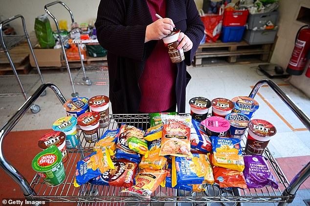 Experts warned that the dire situation would only get worse in the coming months as people are forced to make further cuts due to the cost of living crisis.  Professor Kamila Hawthorne, president of the Royal College of GPs, said: 'There are certainly cases we hear about where parents are not eating meals so their children can eat.  We hear that many people go to the food bank who would never have dreamed of going to a food bank before.'  Volunteers are pictured working at the Weymouth Food Bank distribution center on December 15