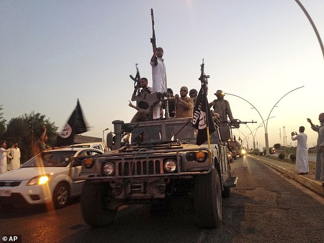 Islamic State group fighters parade in an Iraqi security forces armored vehicle in the northern city of Mosul, Iraq, June 23, 2014