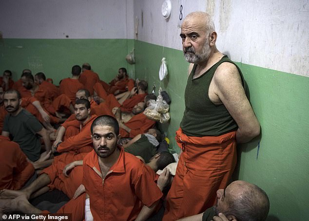 Men suspected of ties to the Islamic State (IS) group gather in a prison cell in the northeastern Syrian city of Hasakeh on October 26, 2019.