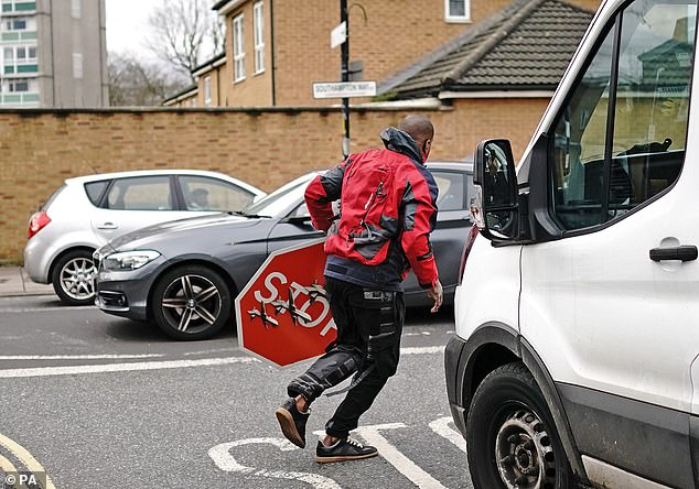 The man in the red jacket fled with the sign as the stunned crowd looked on