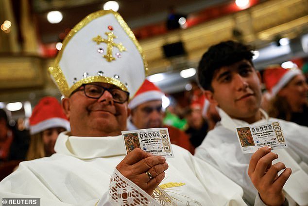 A man dressed as a pope holds up his ticket before the El Gordo lottery drawing