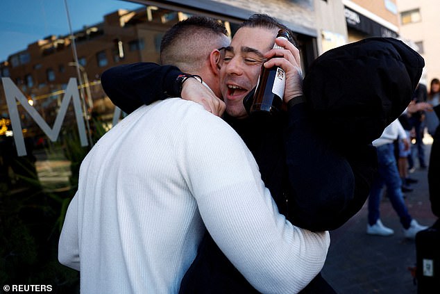 Pedro Valderas hugs his friend Roberto to celebrate winning the first prize of the traditional Spanish Christmas lottery "El Gordo" (The Fat One), outside the restaurant where he bought his ticket, in Madrid, Spain, December 22