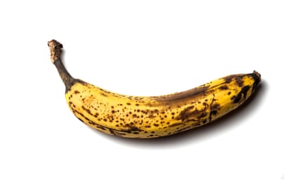 old banana with spots, on a white isolated background