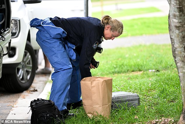 Forensic investigators placed evidence in brown paper bags at the home on Thursday