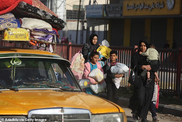 Palestinians living in the Bureij refugee camp leave their homes with their belongings to head towards the city of Deir al-Balah after the Israeli forces asked them to leave the camp in Bureij, Gaza, on December 22, 2023.