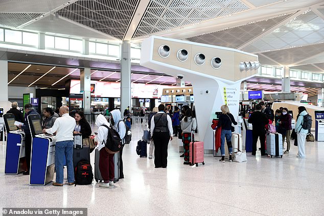 US airlines are bracing for record holiday traffic after boosting their workforces in hopes of avoiding a repeat of last Christmas' operational meltdown.  Pictured: Passengers at Newark Airport in New Jersey try to avoid the holiday crowds