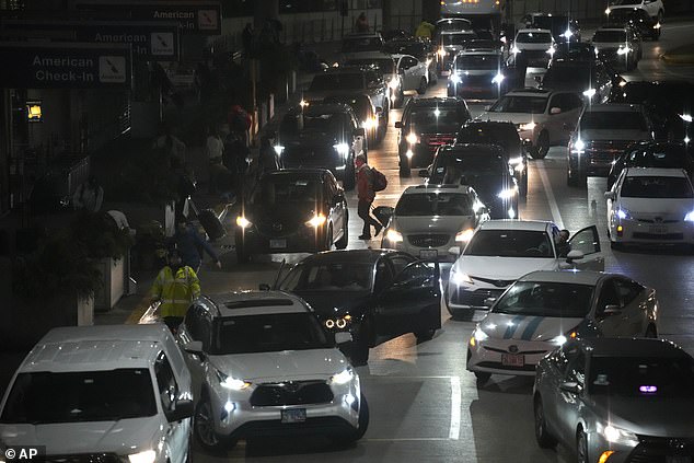 AAA expects about 104 million people to take to the roads during the holiday season, indicating a potential traffic jam.  Pictured: Lines form outside Chicago's O'Hare International Airport