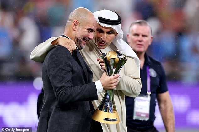 Manager Pep Guardiola enjoys the historic evening as he holds the trophy with chairman Khaldoon Al Mubarak