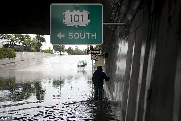 Near the entrance to the 101 Freeway in Santa Barbara, a BMW sedan was swamped by rainwater from the flash floods, leaving the passengers in the middle of a gigantic and deep pool of water