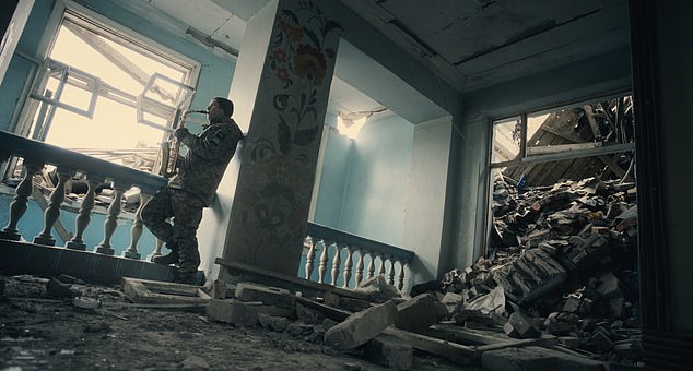 Dmytro Dudko, a soldier from the 59th OMPBr, plays the saxophone in a battered building in Bakhmut