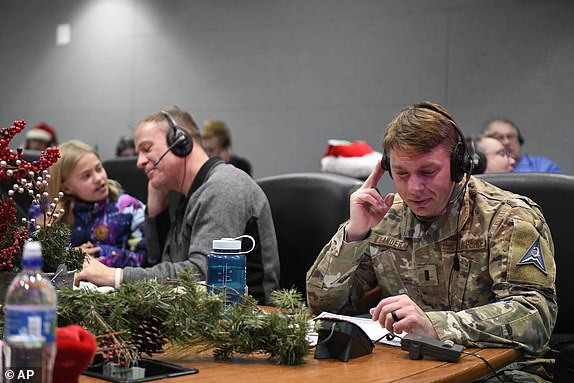 This Department of Defense image shows volunteers answering phones and emails from children around the world during the annual NORAD Tracks Santa event at Peterson Air Force Base in Colorado Springs, Colorado, December 24, 2022. (Chuck Marsh/Department or Defense via AP)