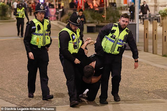 There are also images of the man being dragged away by the police in handcuffs